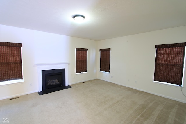 unfurnished living room featuring light colored carpet