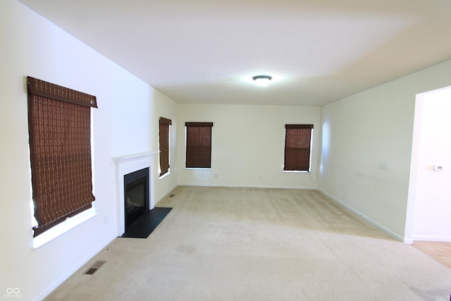 unfurnished living room featuring light carpet