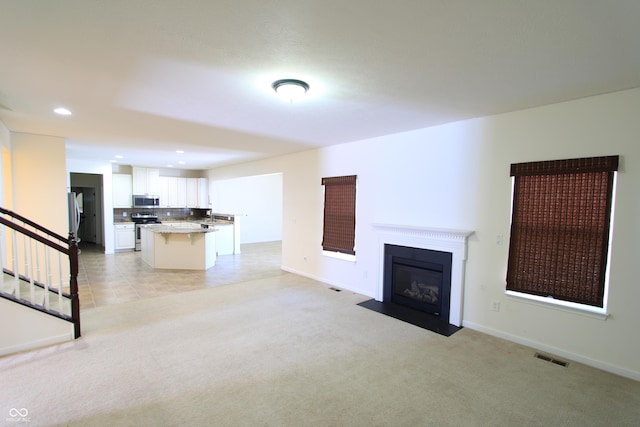 unfurnished living room featuring light carpet