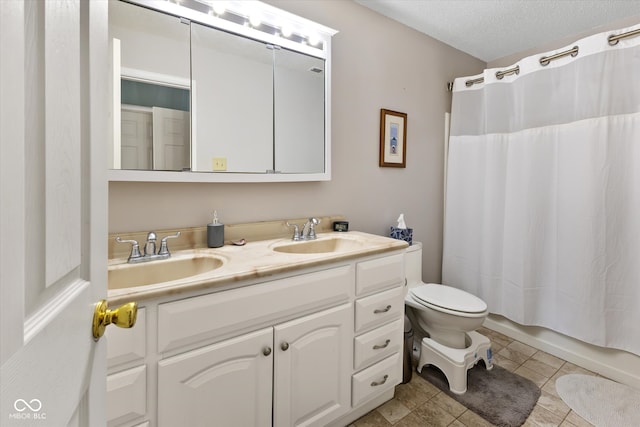 bathroom with vanity, tile patterned flooring, toilet, and a textured ceiling