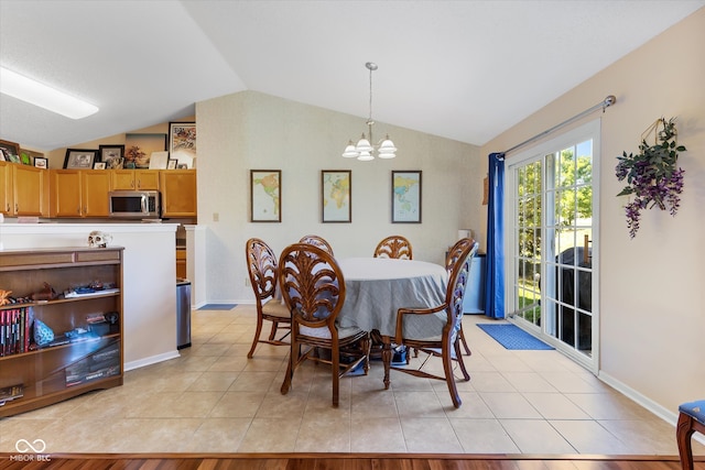 dining space featuring light wood-type flooring, vaulted ceiling, and an inviting chandelier