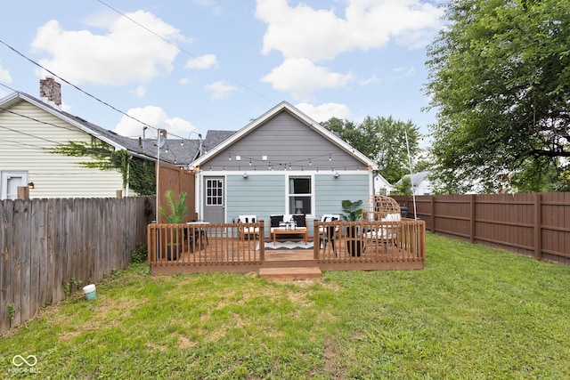 back of house with an outdoor living space, a deck, and a lawn