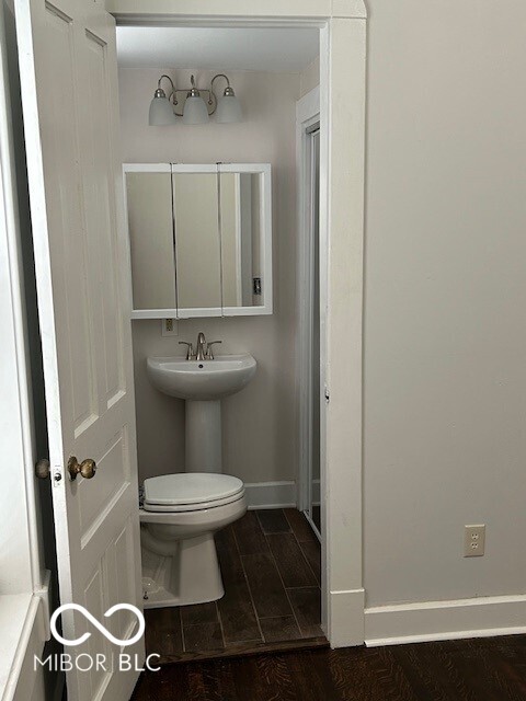 bathroom with wood-type flooring and toilet