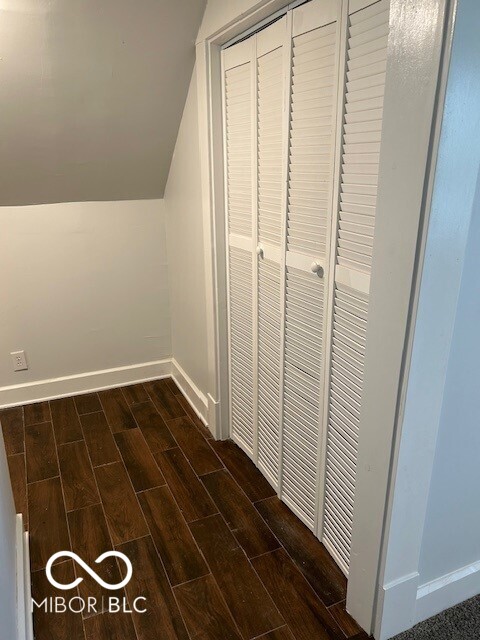 interior space with dark hardwood / wood-style floors and vaulted ceiling