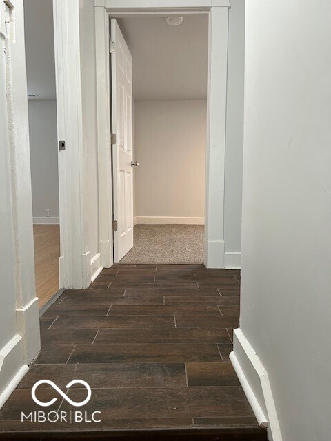 hallway with dark hardwood / wood-style flooring