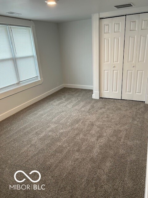 unfurnished bedroom with a closet and carpet flooring