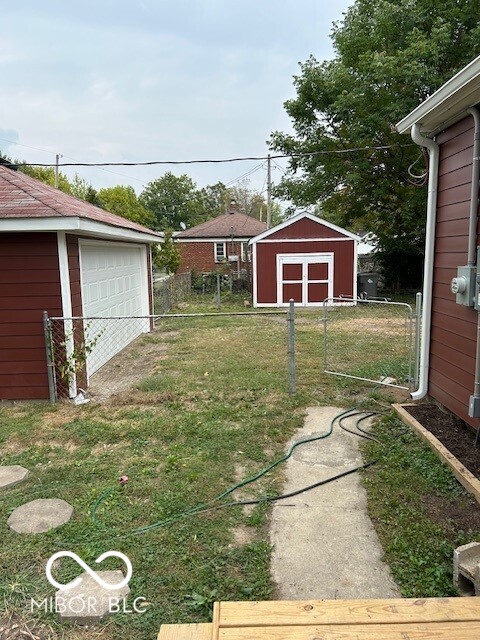 view of yard with a storage unit and a garage