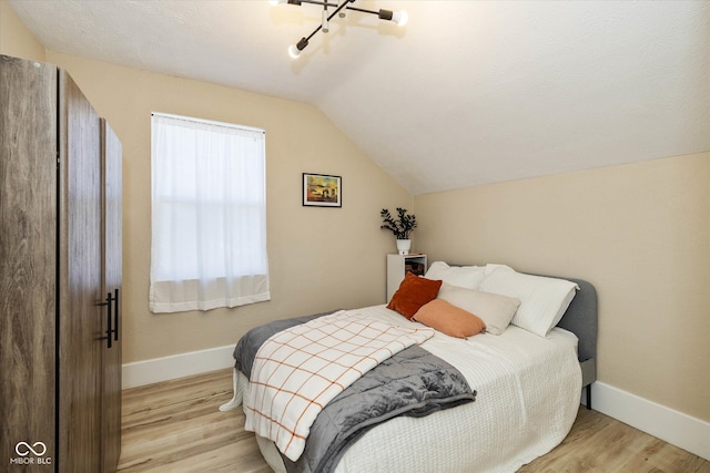 bedroom with vaulted ceiling and light hardwood / wood-style floors