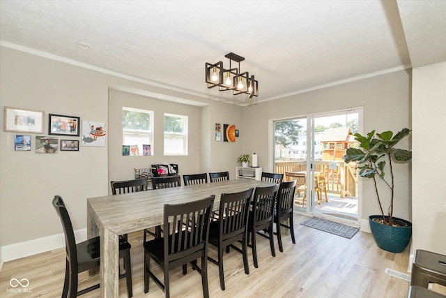 dining area featuring crown molding, light hardwood / wood-style floors, and a healthy amount of sunlight