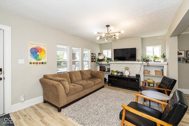 living room with a textured ceiling, light hardwood / wood-style floors, and a chandelier