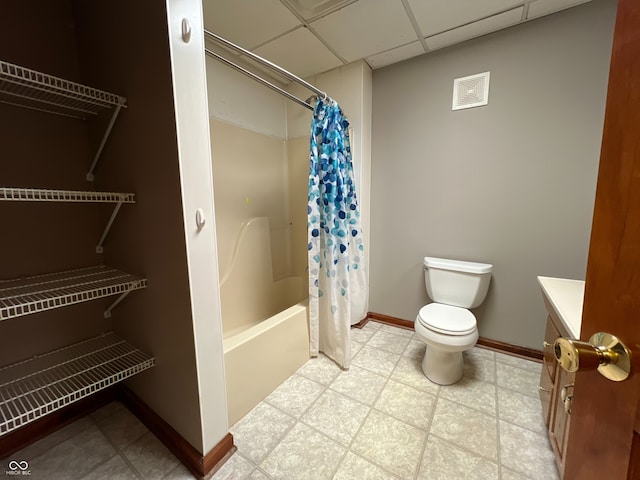 full bathroom with a paneled ceiling, shower / tub combo, tile patterned floors, vanity, and toilet