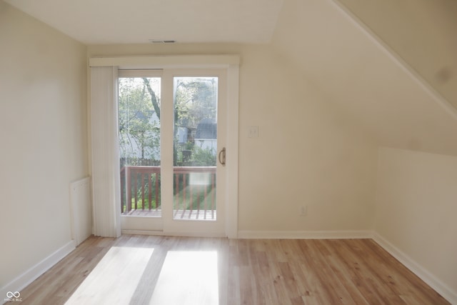 additional living space featuring lofted ceiling and light hardwood / wood-style floors