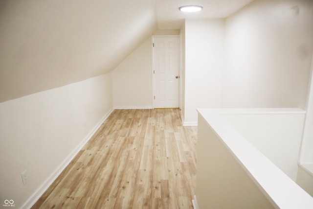 additional living space featuring light hardwood / wood-style flooring and lofted ceiling