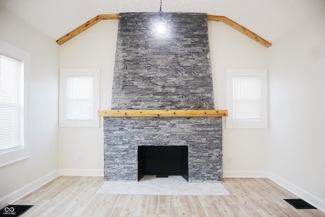 details featuring a fireplace, beam ceiling, and hardwood / wood-style flooring