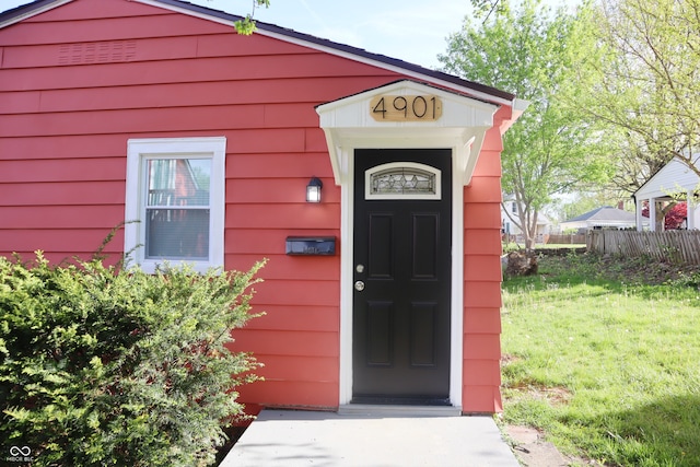 doorway to property with a lawn