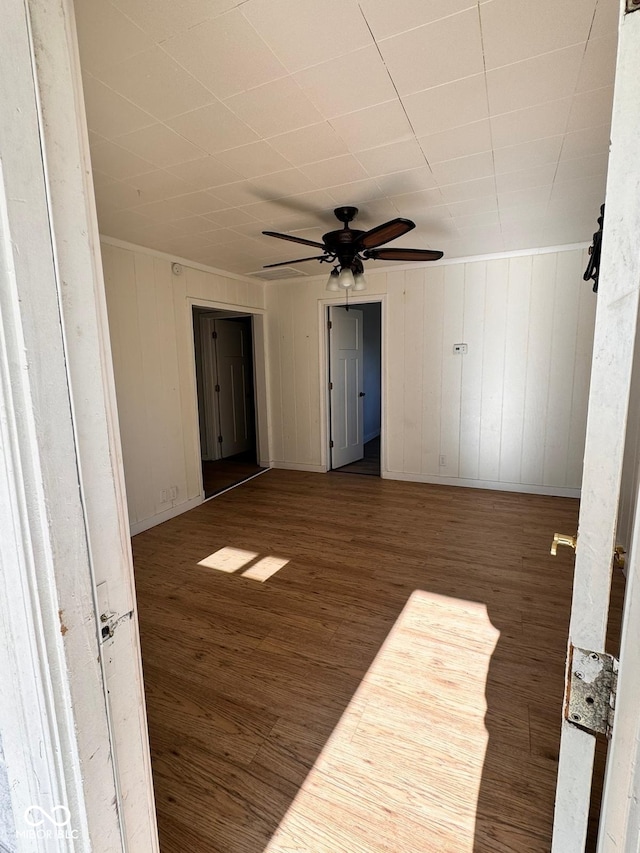 empty room with ceiling fan and dark hardwood / wood-style flooring