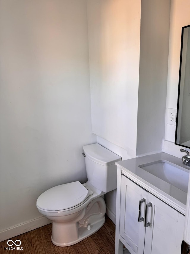 bathroom featuring vanity, toilet, and hardwood / wood-style flooring