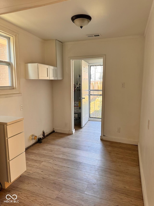 interior space with plenty of natural light, light hardwood / wood-style floors, and crown molding