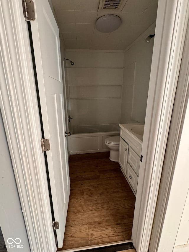 full bathroom featuring hardwood / wood-style floors, shower / tub combination, vanity, and toilet