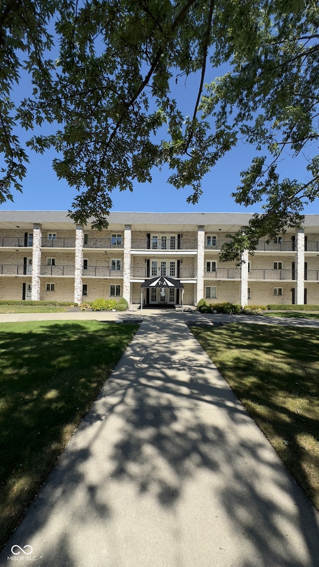 view of front of property featuring a balcony and a front yard