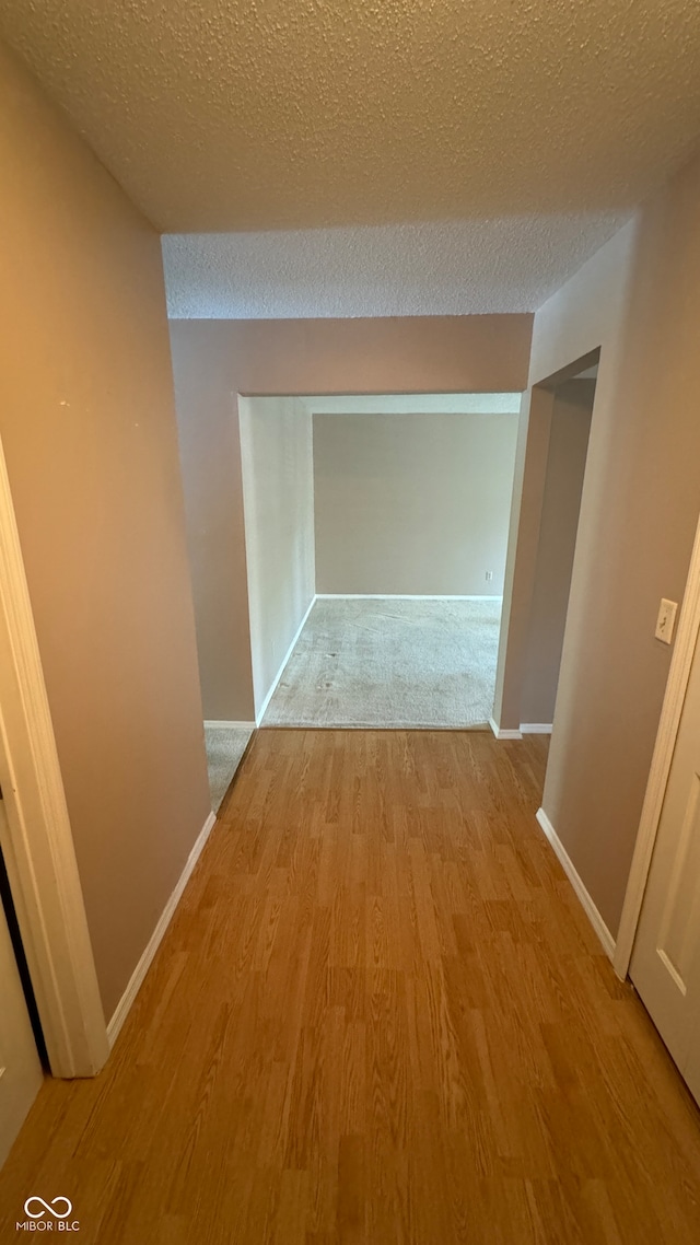 hallway featuring a textured ceiling and light wood-type flooring