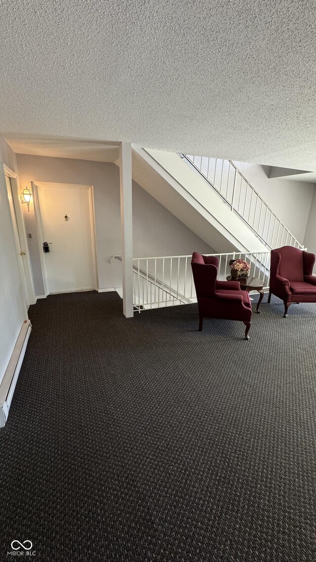 unfurnished room with vaulted ceiling, a textured ceiling, baseboard heating, and carpet flooring