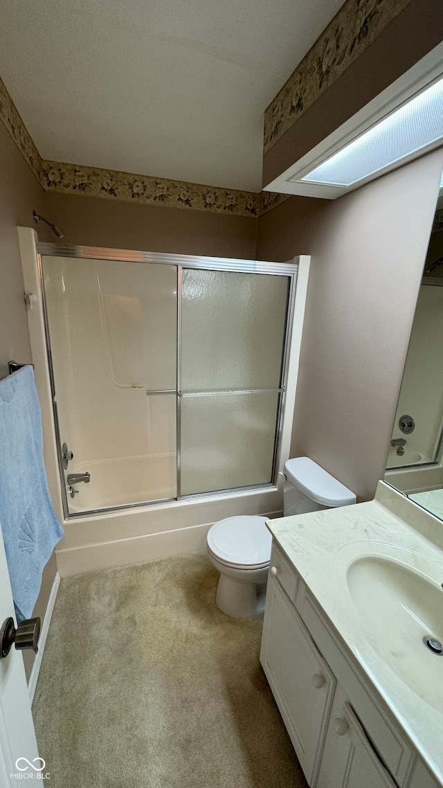 full bathroom with enclosed tub / shower combo, vanity, and toilet