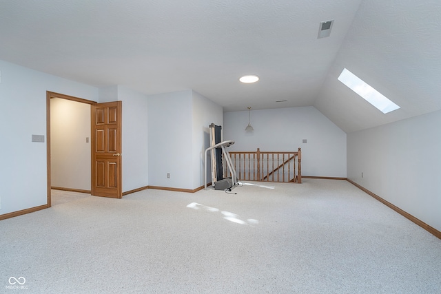 bonus room featuring light colored carpet and lofted ceiling with skylight