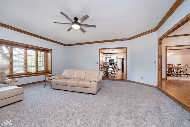 carpeted living room with crown molding and ceiling fan