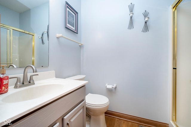 bathroom with a shower with shower door, vanity, toilet, and hardwood / wood-style flooring