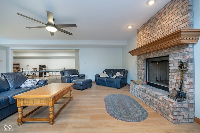 living room with ceiling fan, light hardwood / wood-style floors, and a fireplace