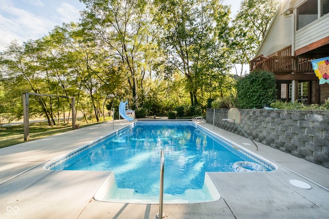 view of swimming pool with a deck and a water slide