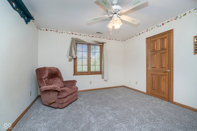 sitting room featuring ceiling fan and carpet floors