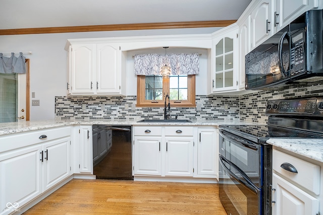 kitchen featuring light hardwood / wood-style flooring, white cabinets, black appliances, and sink