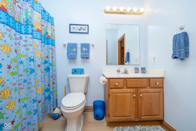 bathroom featuring vanity, walk in shower, hardwood / wood-style floors, and toilet