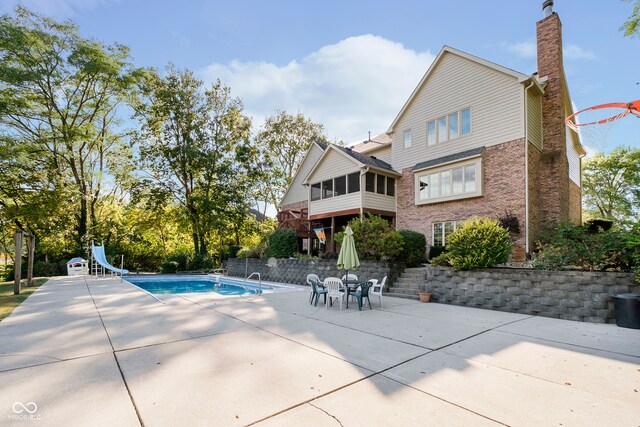 view of swimming pool featuring a patio and a water slide