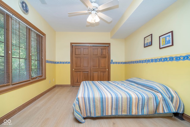 bedroom featuring a closet, light hardwood / wood-style floors, and ceiling fan