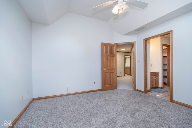 unfurnished bedroom featuring a closet, lofted ceiling, light colored carpet, a spacious closet, and ceiling fan