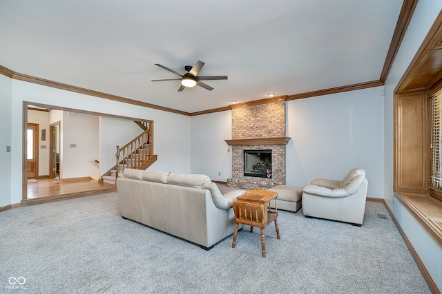 living room with ceiling fan, a brick fireplace, a textured ceiling, light carpet, and crown molding