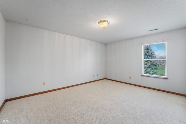 spare room featuring carpet flooring and a textured ceiling