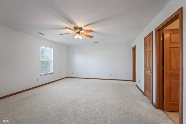 unfurnished bedroom featuring a textured ceiling, ceiling fan, and light carpet