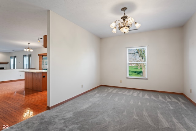 spare room featuring a chandelier and wood-type flooring