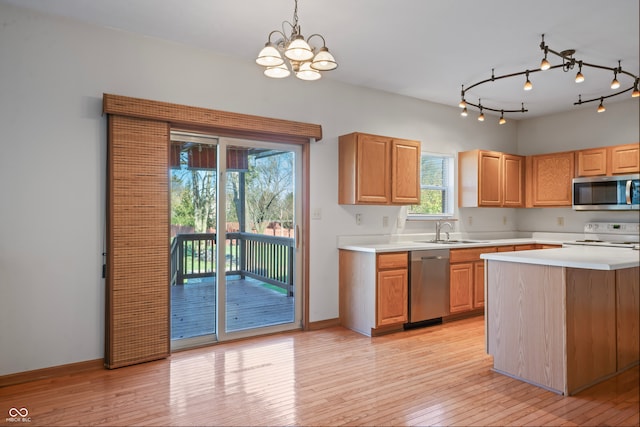 kitchen featuring sink, decorative light fixtures, appliances with stainless steel finishes, a notable chandelier, and light hardwood / wood-style floors