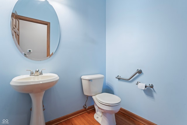 bathroom with hardwood / wood-style flooring, toilet, and sink