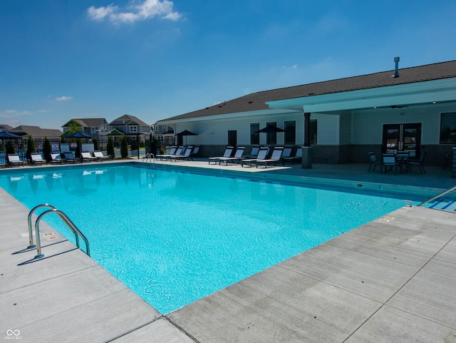 community pool featuring fence and a patio