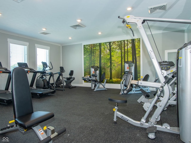 exercise room with baseboards, visible vents, and ornamental molding