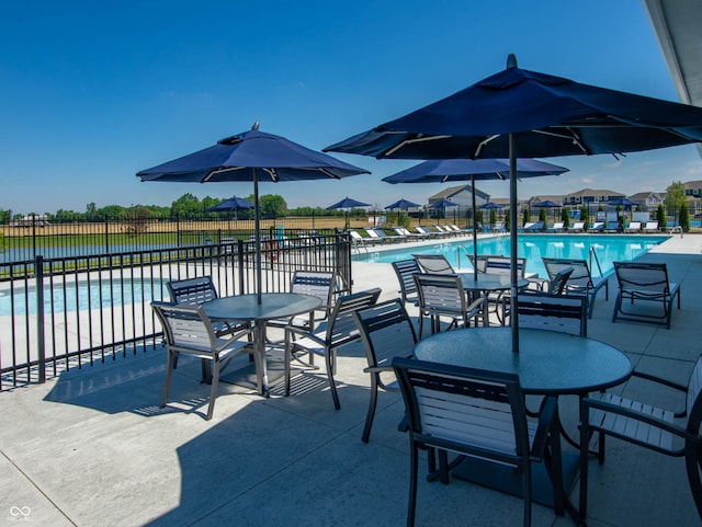 view of patio with a community pool and fence