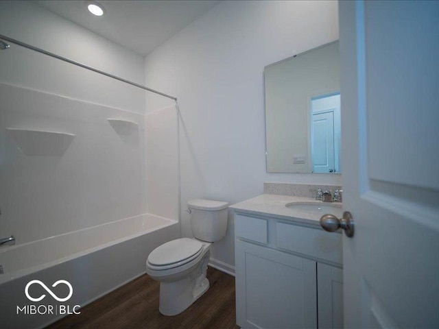 bathroom featuring toilet, vanity, wood finished floors, and bathing tub / shower combination