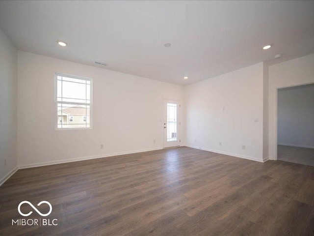 spare room with dark wood-type flooring, recessed lighting, visible vents, and baseboards