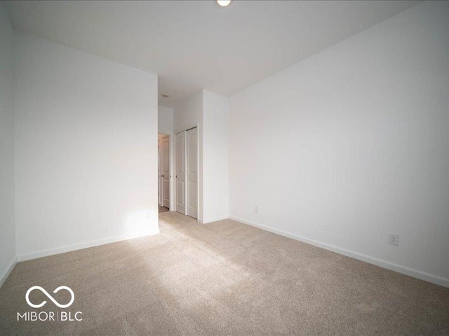 spare room featuring carpet and baseboards